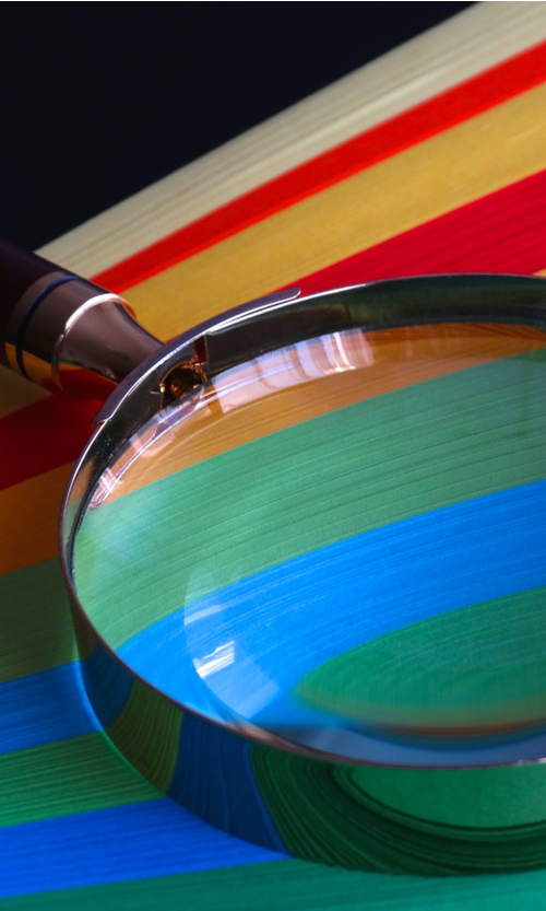 Magnifying glass on multi-coloured paper